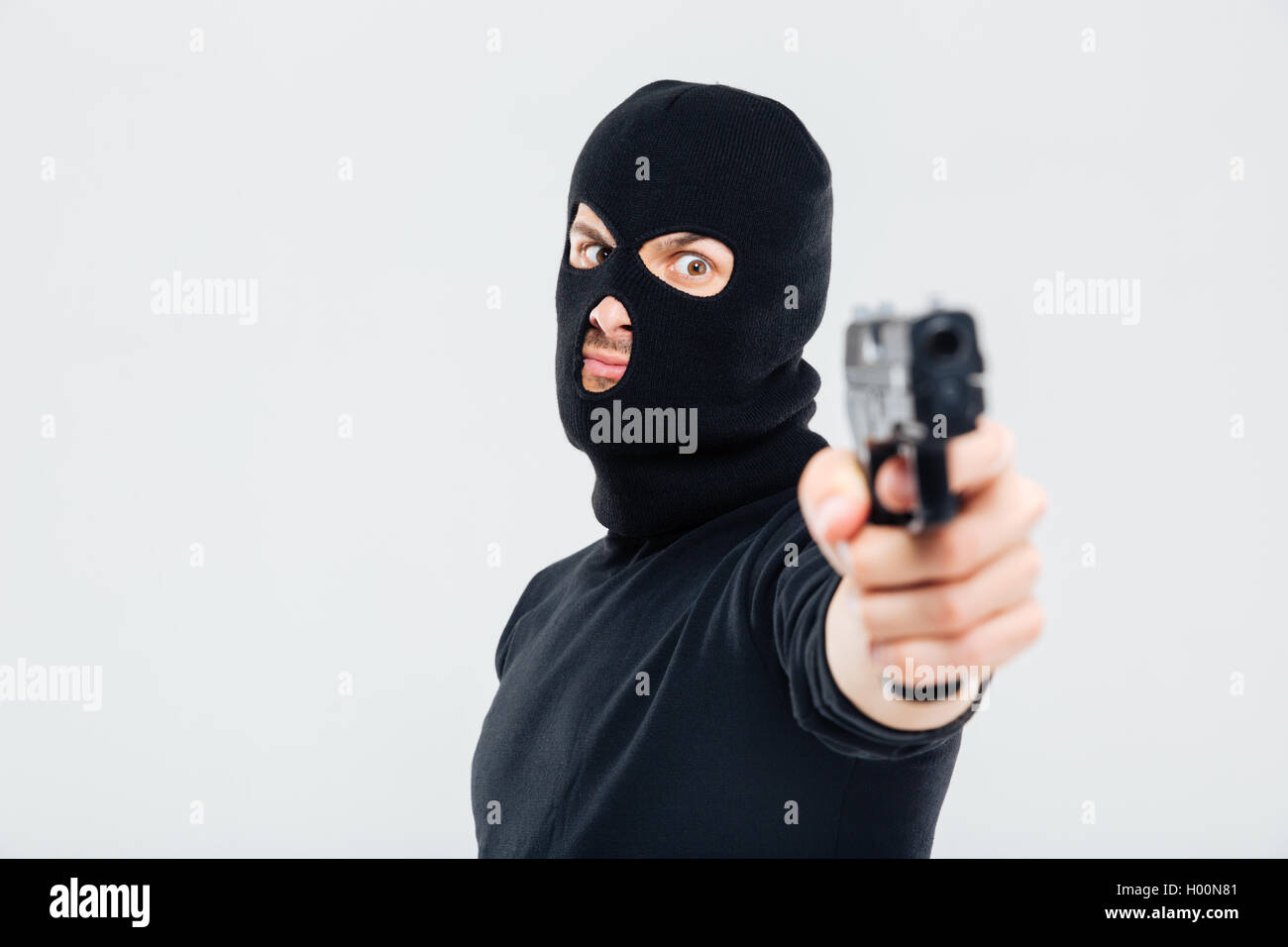 Primo piano di uomo in passamontagna e permanente mira con la pistola Foto  stock - Alamy