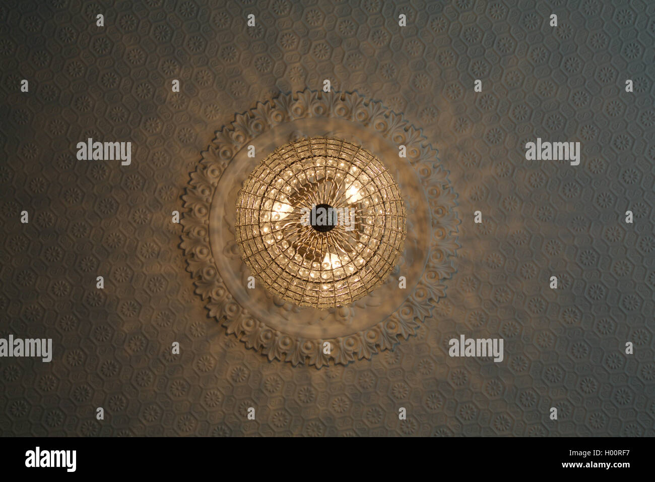 Una sfera di cristallo chandelier luce su un raffinato rosone in stile vittoriano ristrutturato Casa elegante con pattern di luce vista al di sotto Foto Stock