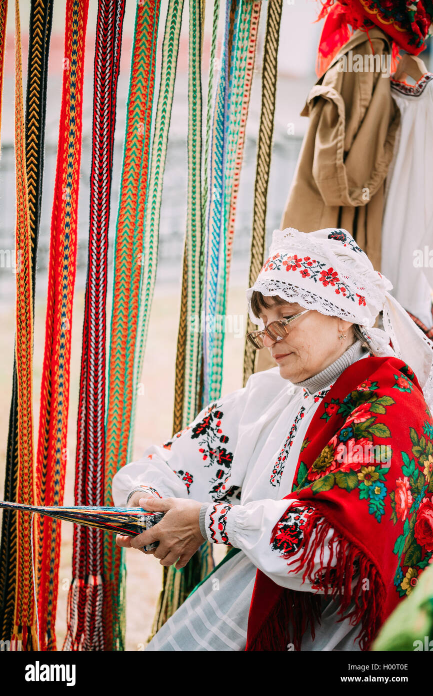 Gomel, Bielorussia - Settembre 12, 2015: Donna in nazionale bielorussa costume folk cinghia di tessitura Foto Stock