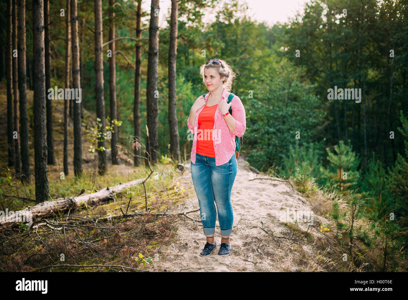 Bella la dimensione più giovane donna in camicia in posa nella Foresta estate a sfondo dei boschi Foto Stock