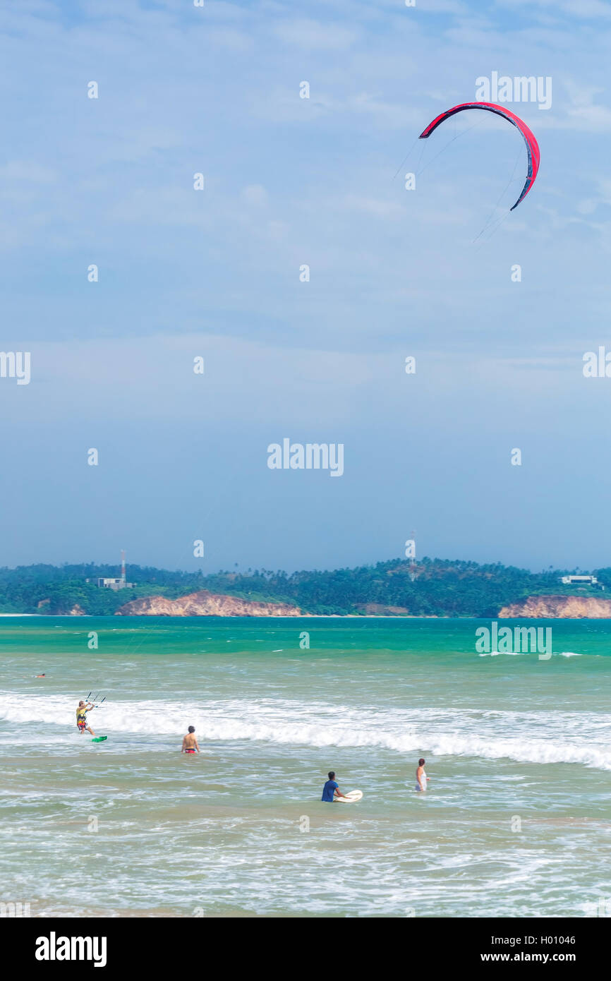 WELIGAMA, SRI LANKA - Marzo 7, 2014: turisti nuotare e praticare il kitesurf in mare. Il turismo e la pesca sono due attività principale in Foto Stock