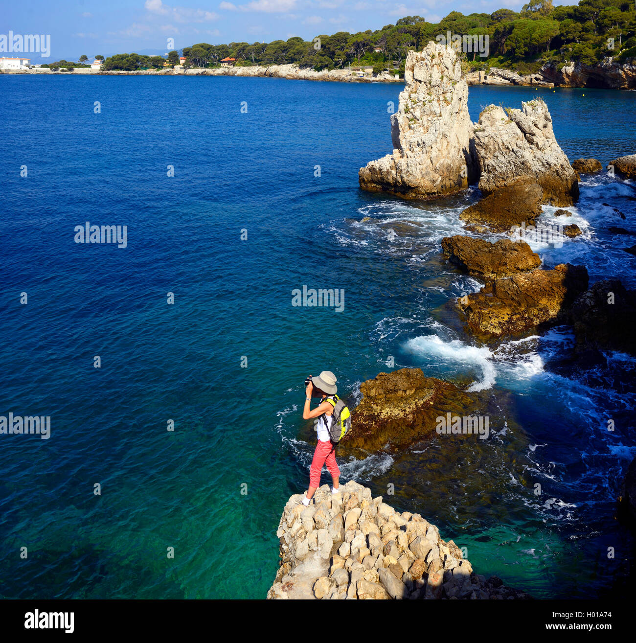 Donna di fotografare la costa rocciosa, Francia, Alpes Maritimes, Antibes Foto Stock
