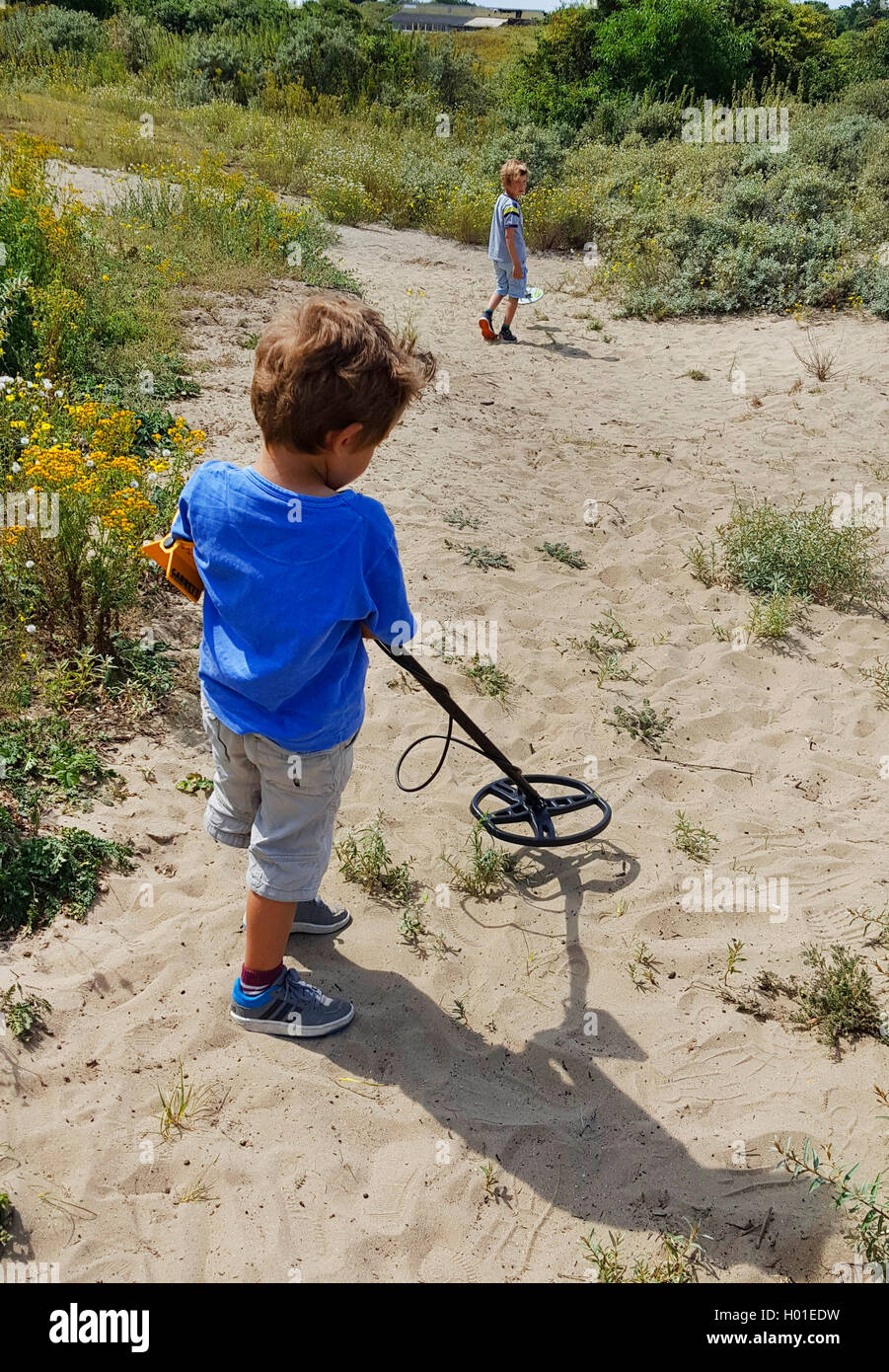 Due bambini di andare a caccia al tesoro con i rivelatori di metallo, Paesi Bassi Foto Stock