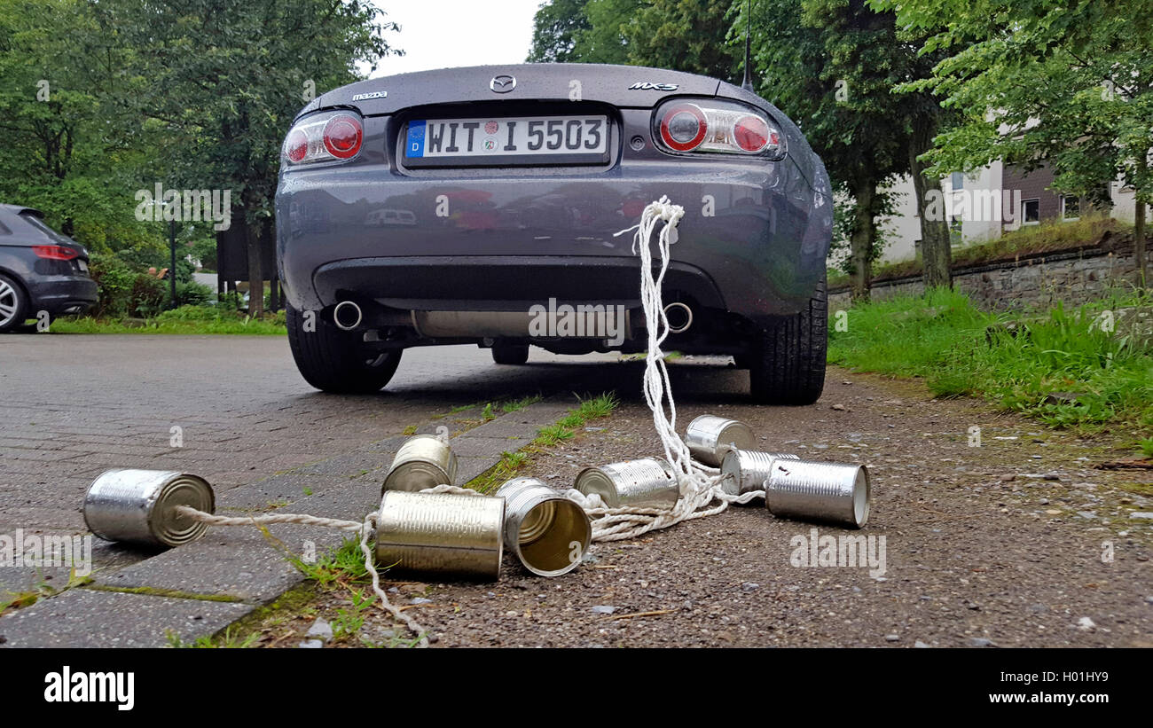 Svuotare le lattine di alluminio sono legati con spago per la coppia auto, Germania Foto Stock
