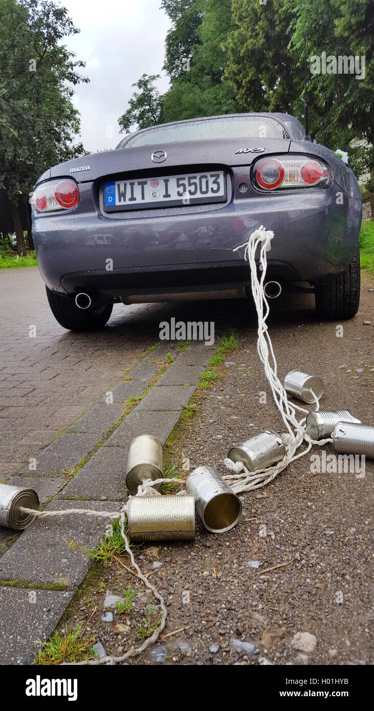 Svuotare le lattine di alluminio sono legati con spago per la coppia auto, Germania Foto Stock