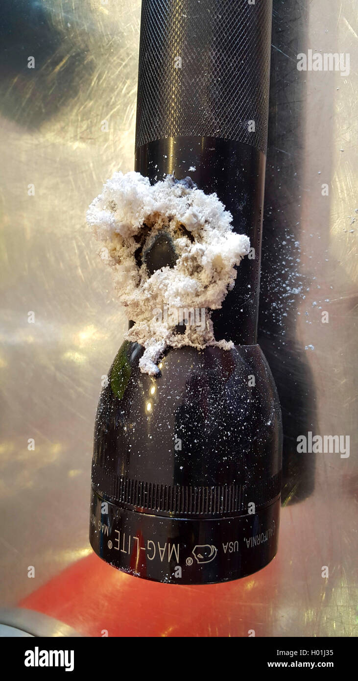 Fiocchi bianchi deposizioni su una lampada tascabile causato dalla perdita-le batterie danneggiate Foto Stock