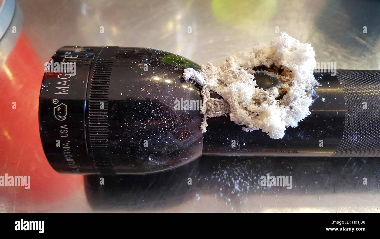 Fiocchi bianchi deposizioni su una lampada tascabile causato dalla perdita-le batterie danneggiate Foto Stock