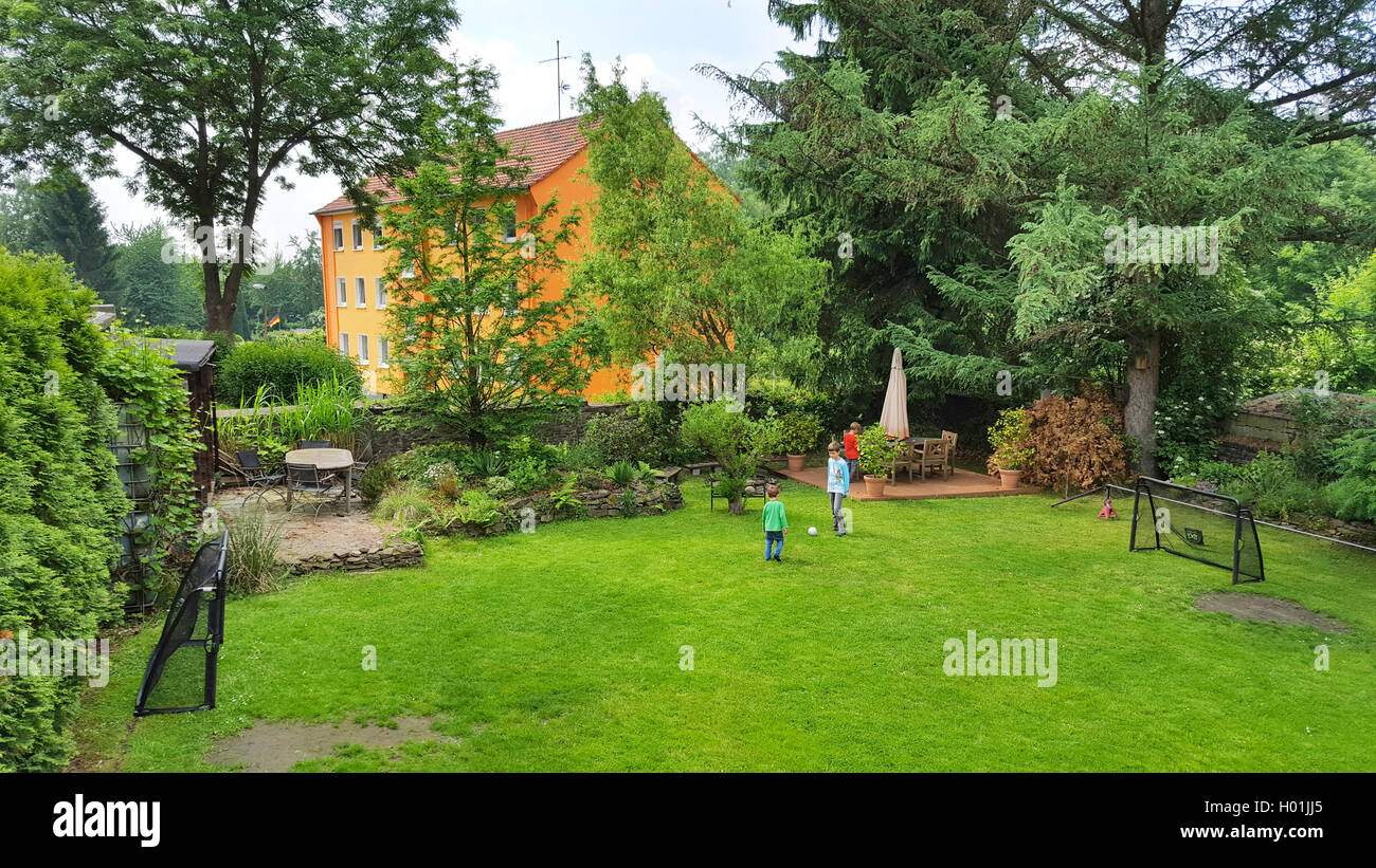 Due bambini che giocano a calcio in un giardino, Germania Foto Stock