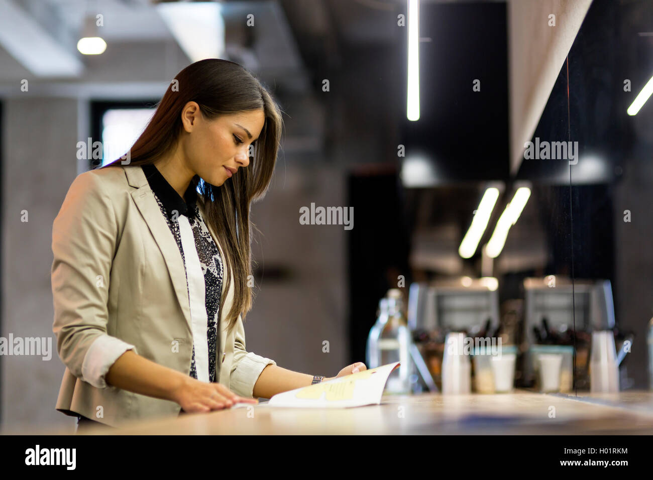 Bella donna la lettura del menu su un bancone di un bar Foto Stock