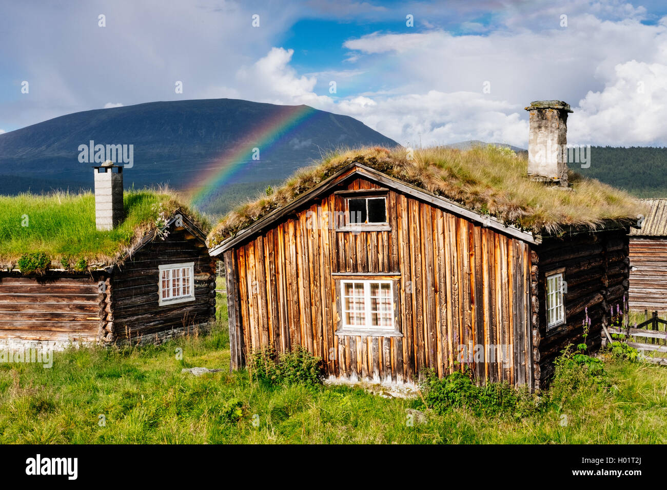 Il vecchio tetto di erba Case sotto un arcobaleno nei pressi di Lom, Oppland, Norvegia Foto Stock