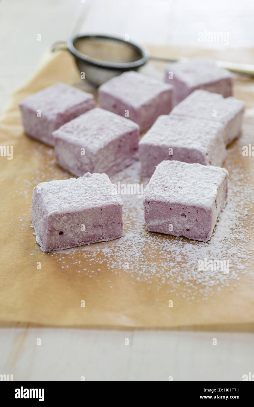 In casa di blackberry e rose marshmallows essendo tagliato e spolverato con zucchero a velo. Foto Stock