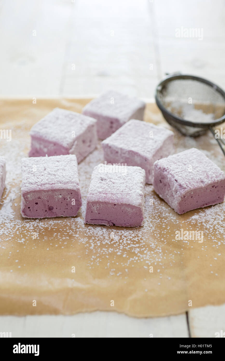 In casa di blackberry e rose marshmallows essendo tagliato e spolverato con zucchero a velo. Foto Stock