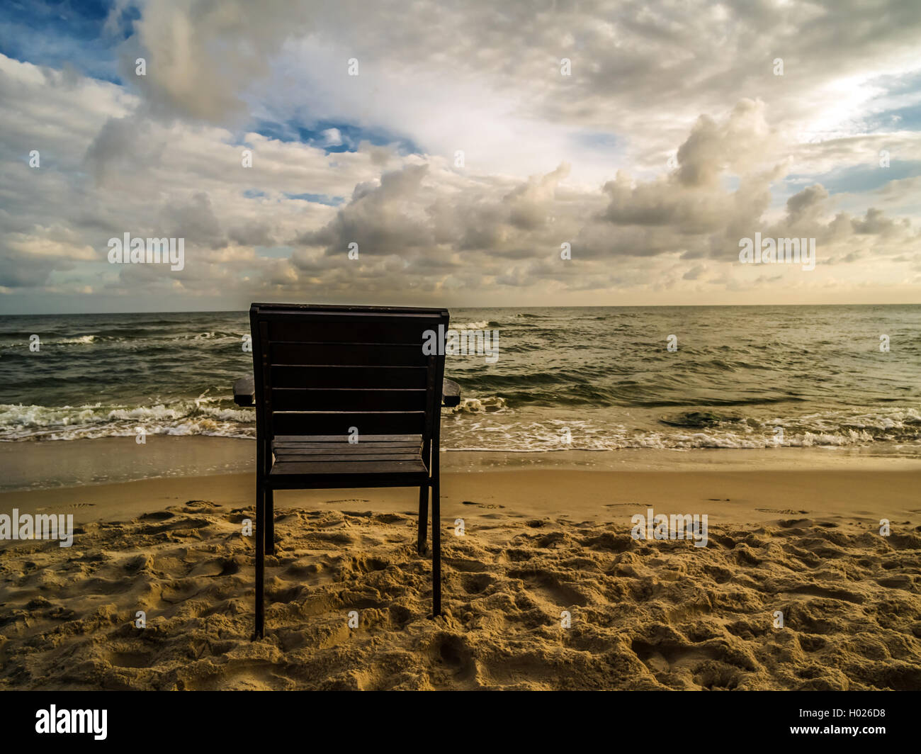 Poltroncina in legno posto sulla spiaggia con vista sul mare Foto Stock