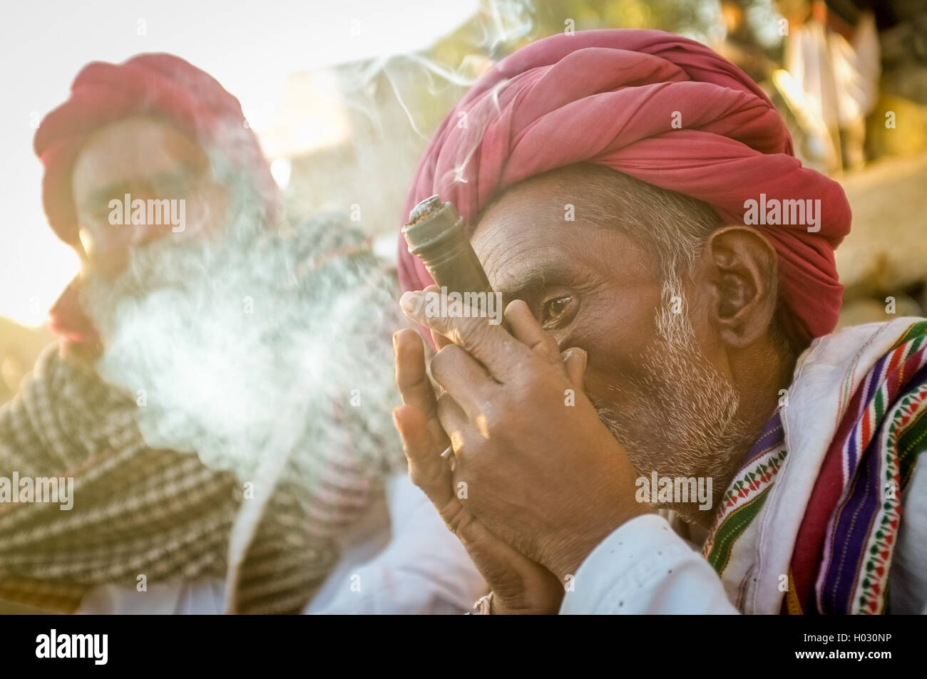 Regione GODWAR, India - 14 febbraio 2015: Anziani Rabari tribesman con turbante rosso e coperta fuma chillum. Rabari Rewari o un Foto Stock