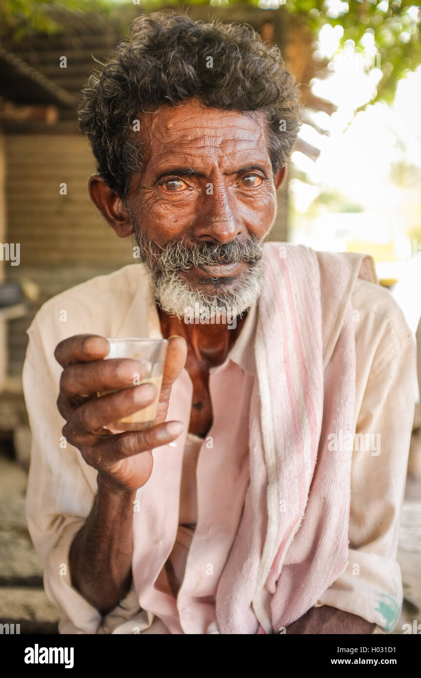 HAMPI, India - 31 gennaio 2015: Anziani uomo indiano tenendo un bicchiere di chai Foto Stock