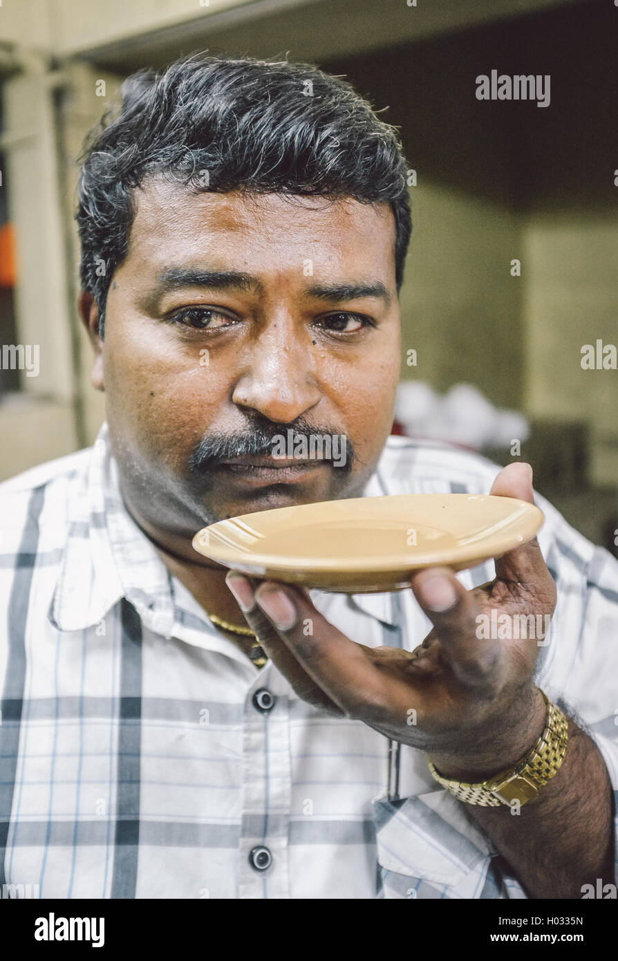 MUMBAI, India - 05 febbraio 2015: Ritratto di uomo indiano bevande latte tè in stile tradizionale. Post-elaborati con grano, textur Foto Stock