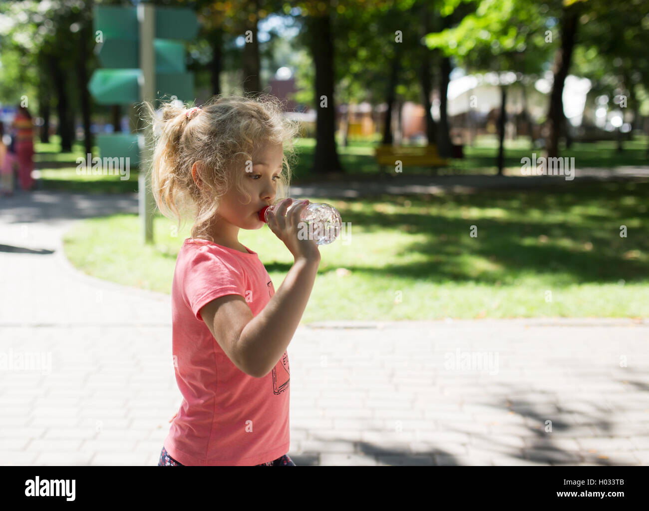 Bambina con una bottiglia di acqua minerale, esterna di estate Foto Stock