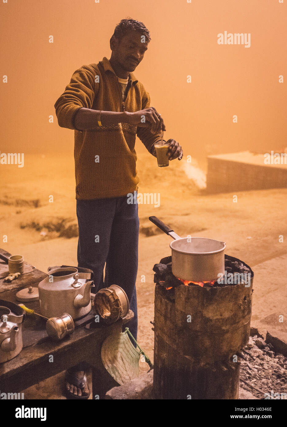 VARANASI, India - 20 febbraio 2015: venditore ambulante prepara il tè lattiginoso sul carbone forno in Varanasi ghat. Post-elaborati con grano, t Foto Stock