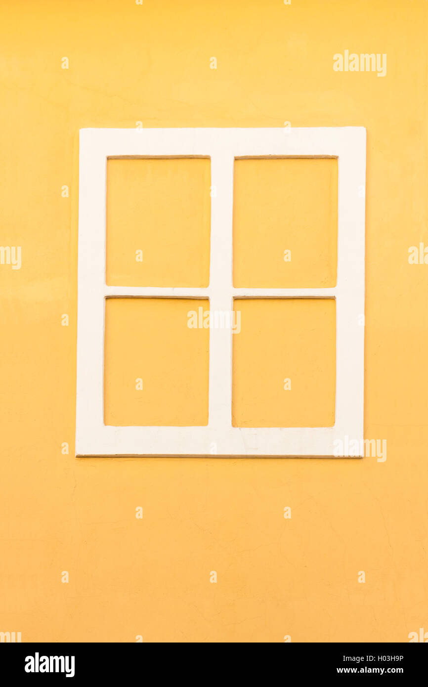 Finestra bianca senza telaio di vetro in una parete di colore giallo Foto Stock