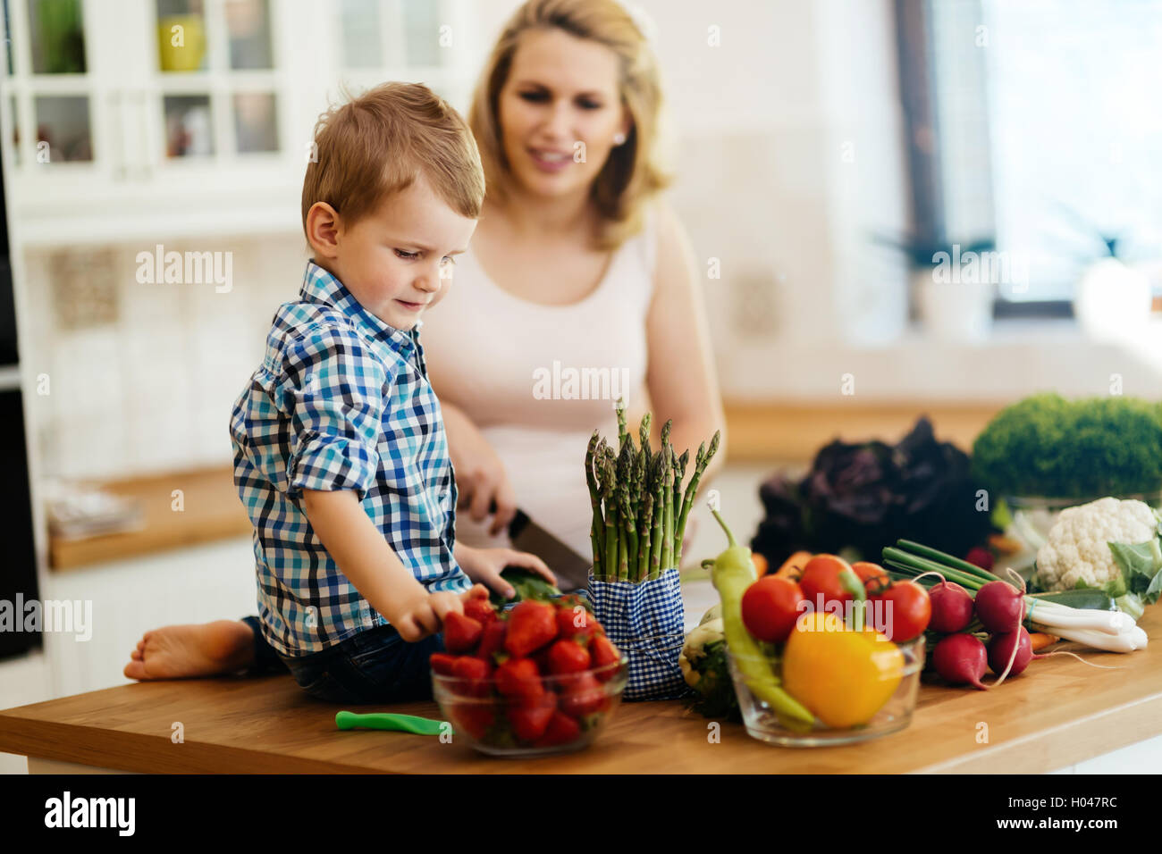 La madre e il bambino a preparare il pranzo da verdure fresche Foto Stock