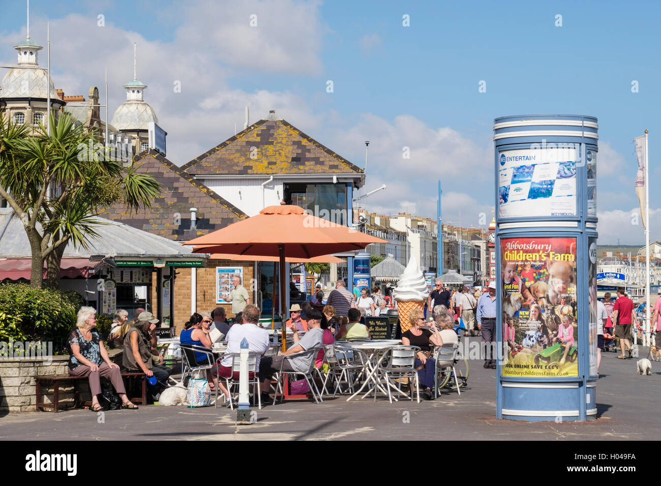 Persone a pranzo nel sole al di fuori di un marciapiede cafe gelateria a Weymouth lungomare. Melcombe Regis Weymouth Dorset England Regno Unito Gran Bretagna Foto Stock