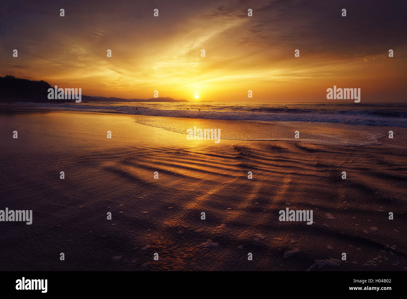 Golden tramonto sulla spiaggia con sole riflessioni di acqua Foto Stock