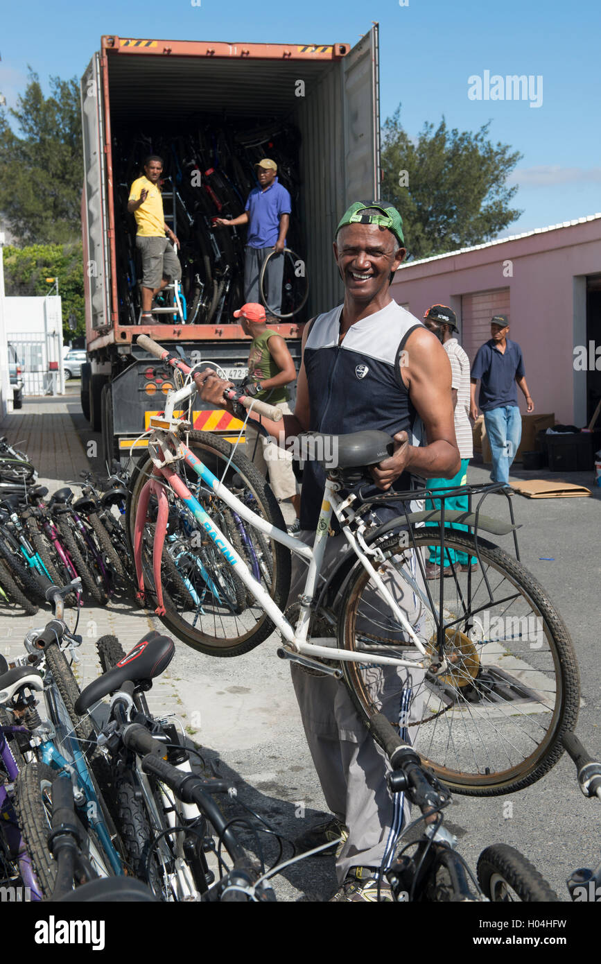Noleggio meccanica scarico biciclette donati fron un contenitore, Cape Town, Sud Africa Foto Stock