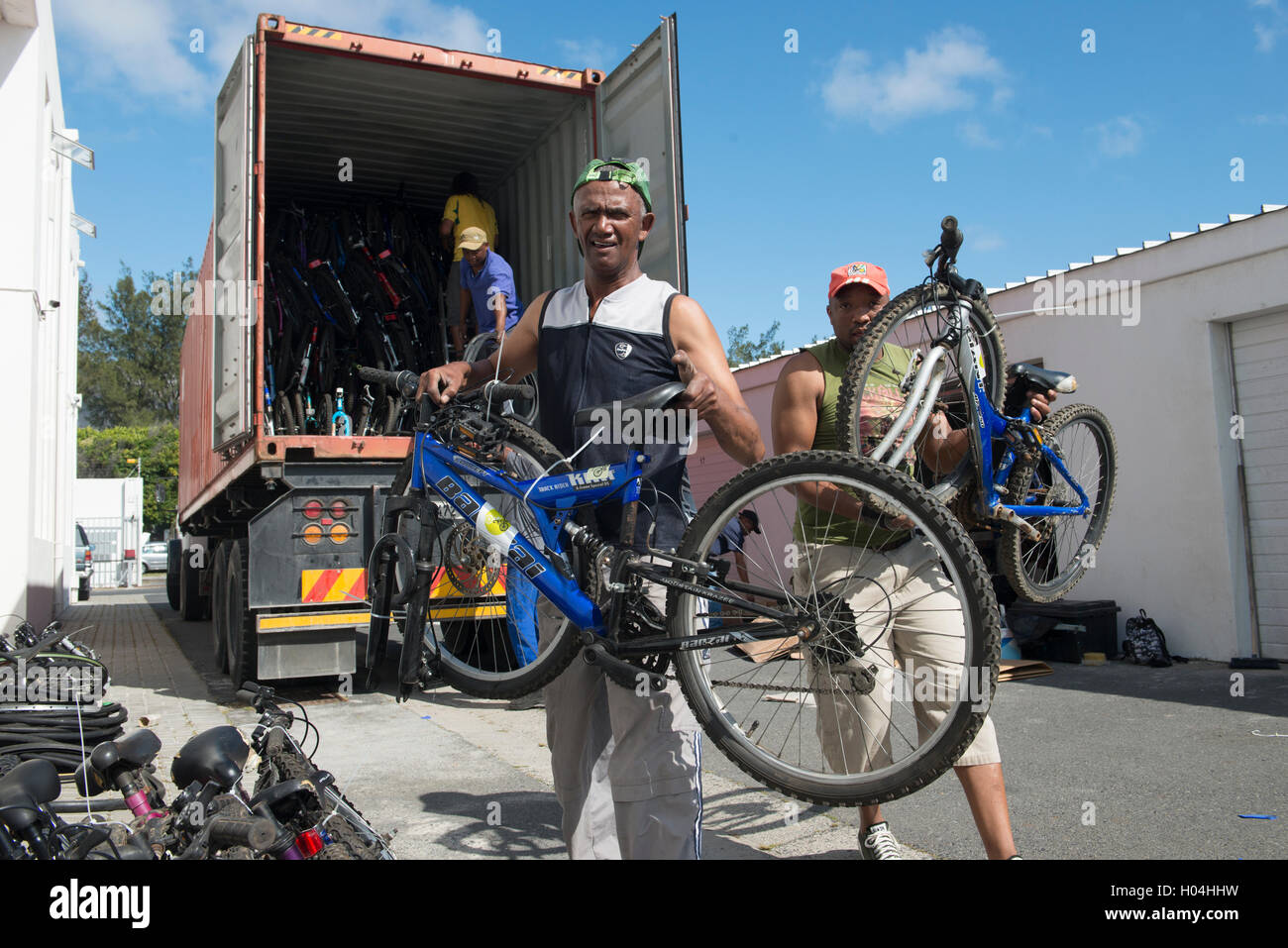 Noleggio meccanica scarico biciclette donati fron un contenitore, Cape Town, Sud Africa Foto Stock