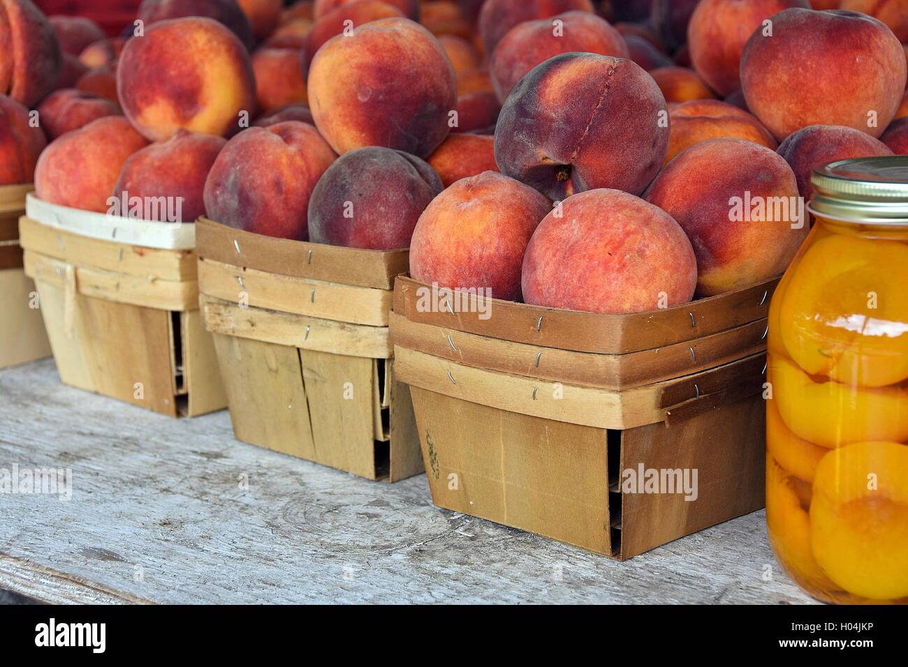 Mature le pesche nel produrre scatole e mason jar Foto Stock