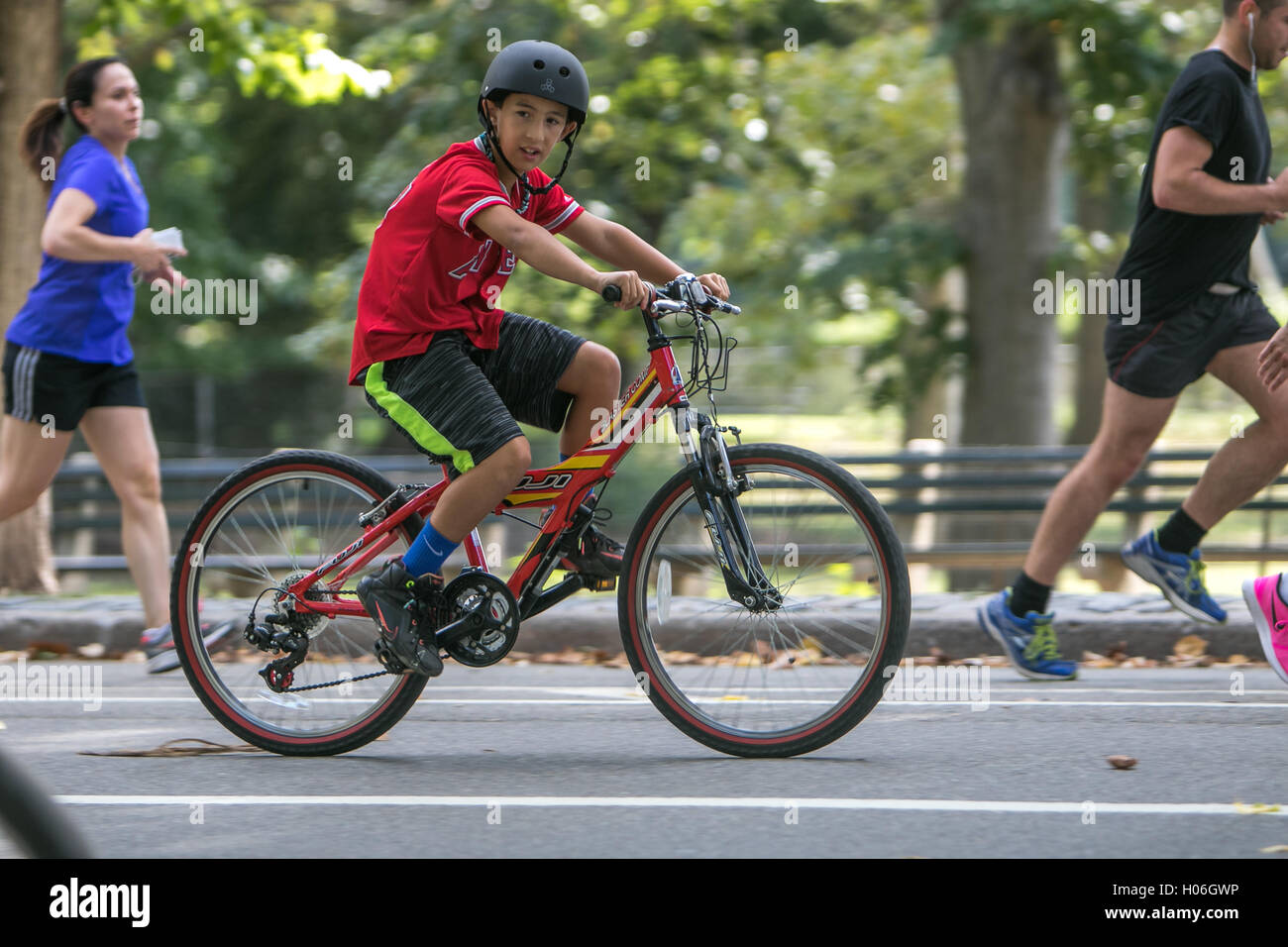 Un bambino è in sella alla sua bicicletta nel parco centrale. Foto Stock