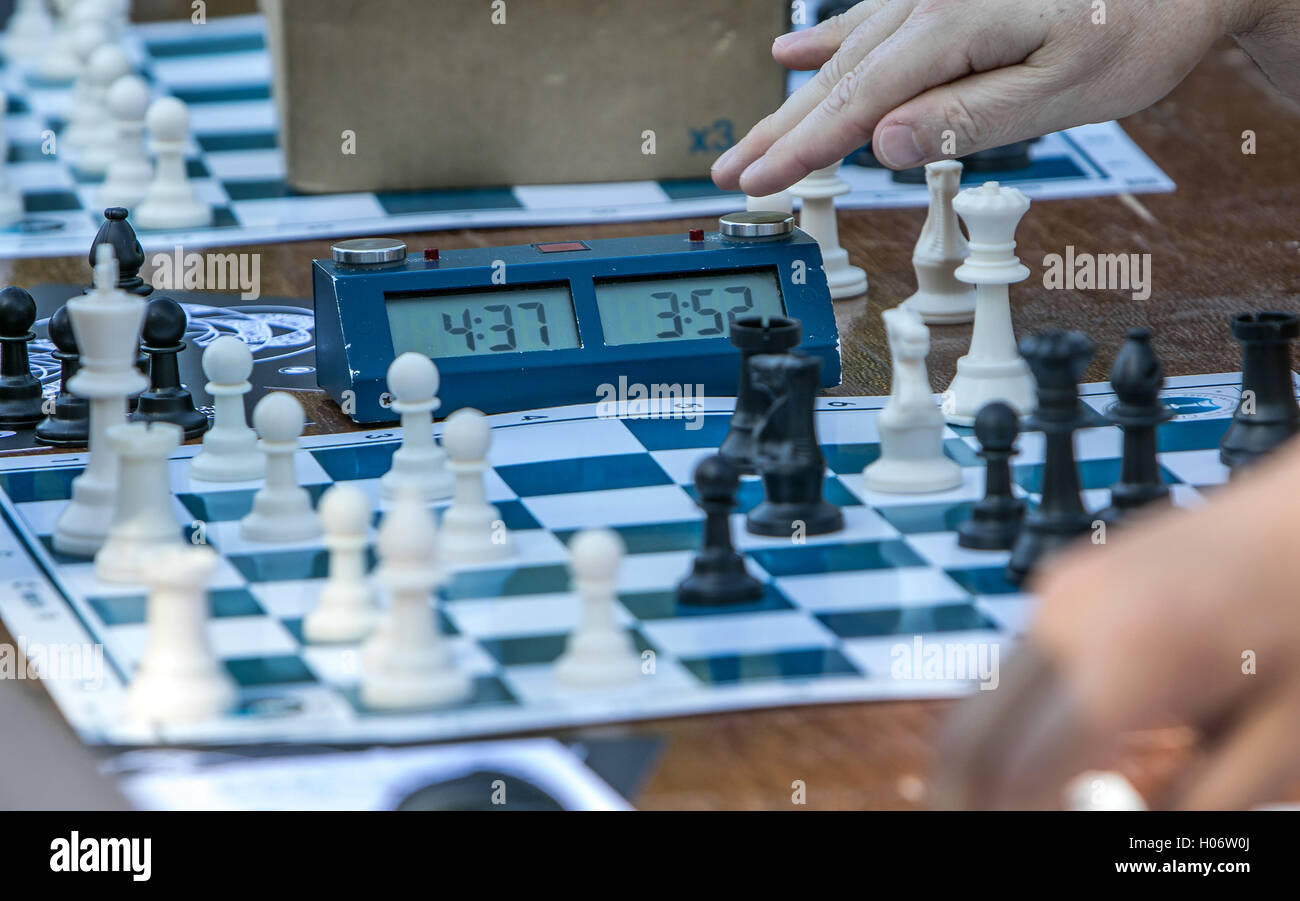 Un gioco di scacchi è in corso un giocatore sta completando una mossa. Foto Stock