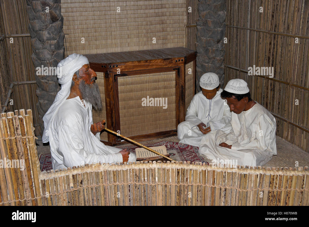 L insegnante e gli studenti imparare il Corano, presentano in Hatta Heritage Village, Dubai, Emirati Arabi Uniti Foto Stock