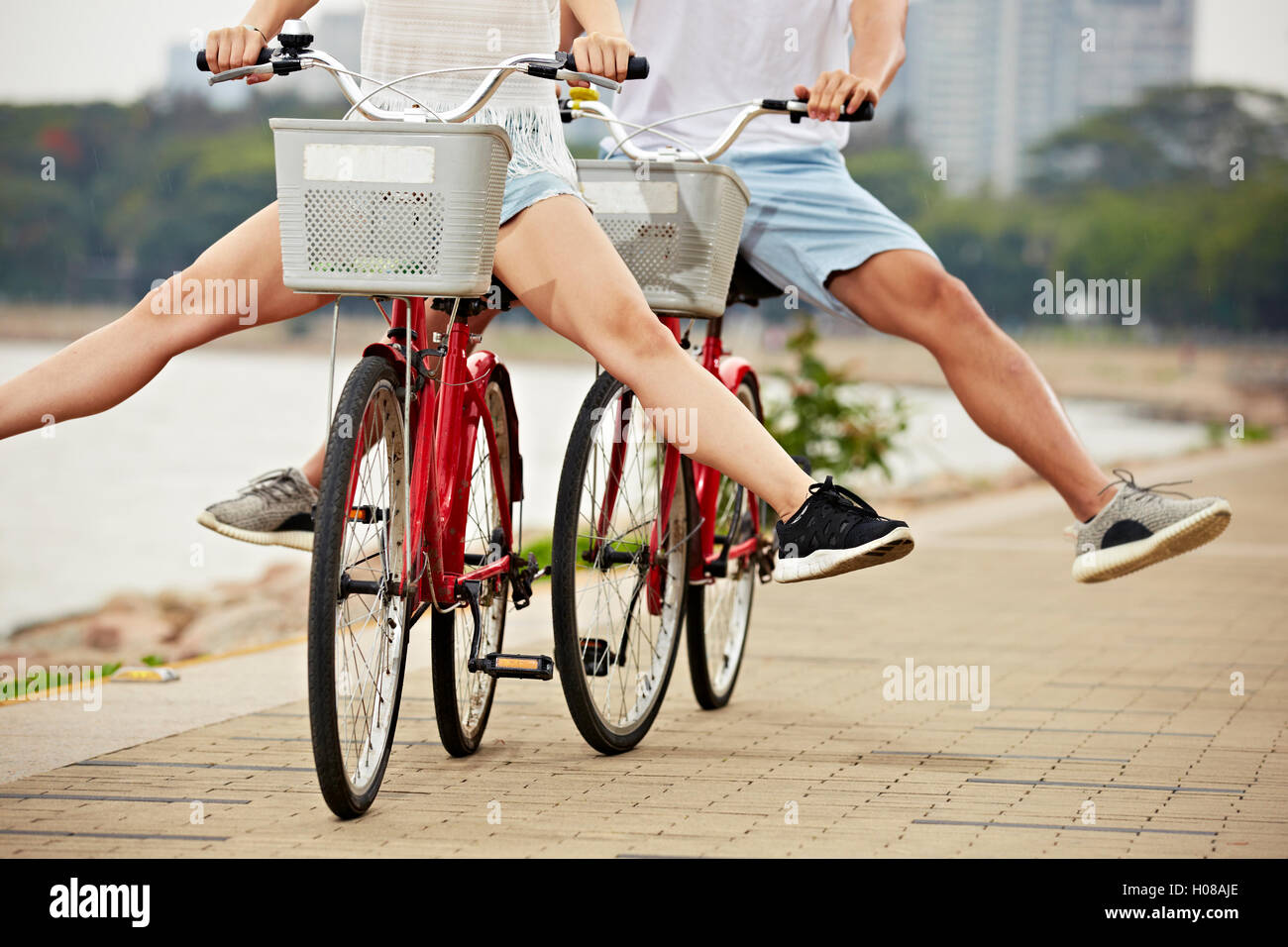 Giovane uomo e donna avente fun riding bike nel parco Foto Stock