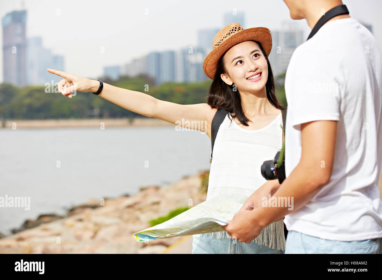 Giovani asiatici giovane turista cercando di individuare uno scenario spot utilizzando una mappa Foto Stock