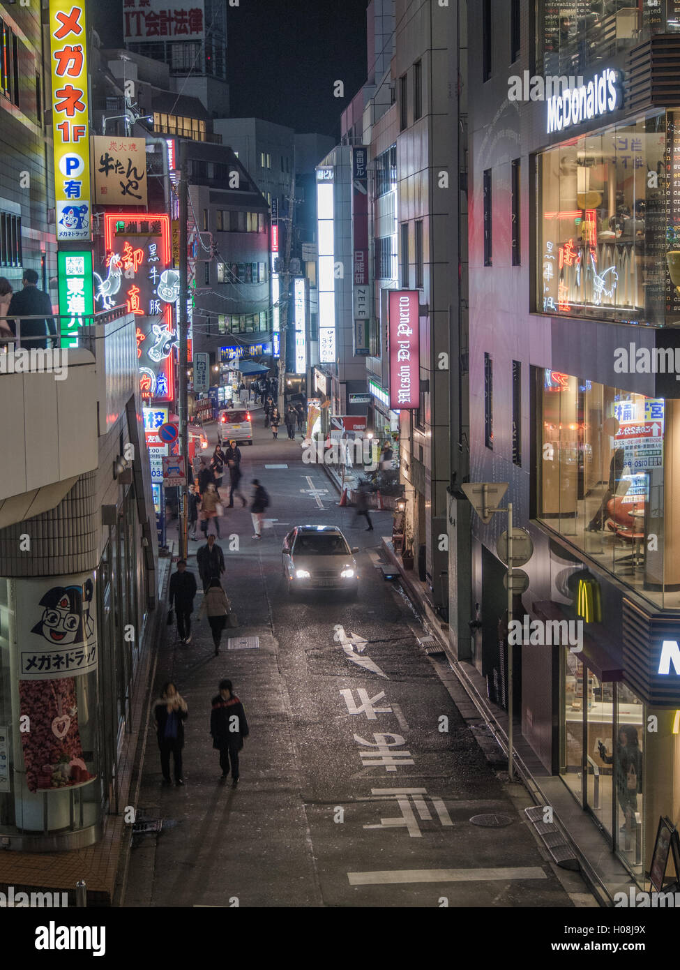 Strada di città di notte, Omiya, Saitama, Giappone con Mcdonalds, gente che passeggia, insegne al neon Foto Stock