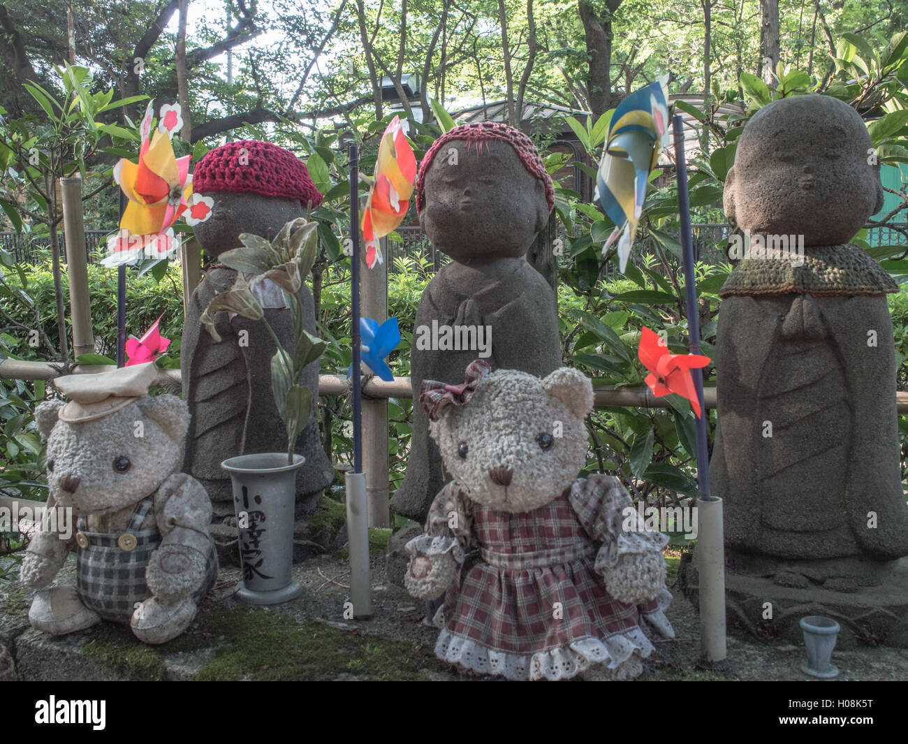 Jizo statue, con offerte di giocattoli, il tempio di Zojo-ji, Minato, Tokyo, Giappone Foto Stock