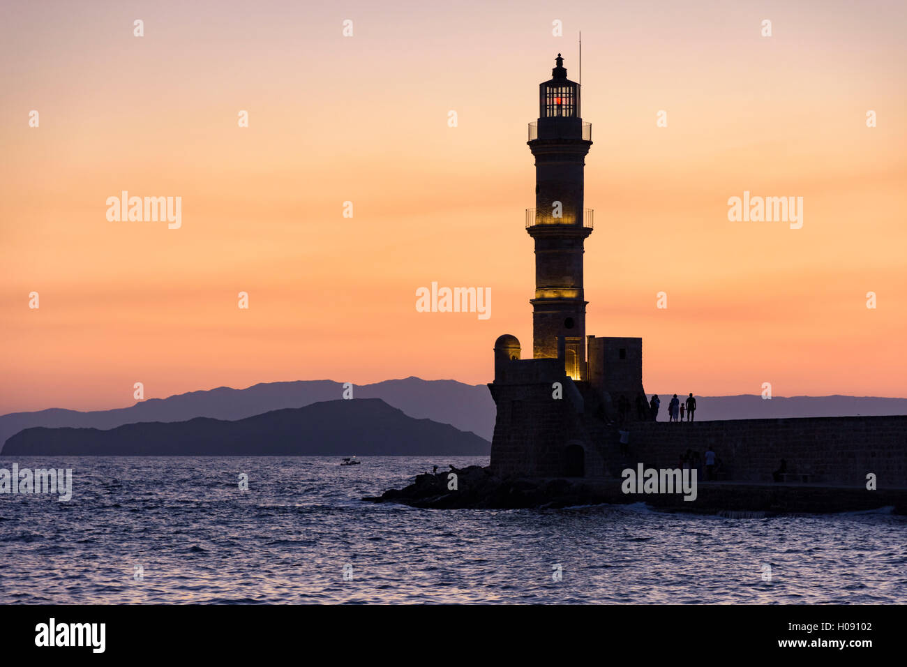 Vista tramonto sopra il faro di Chania all'ingresso del porto veneziano di Chania, Creta, Grecia Foto Stock