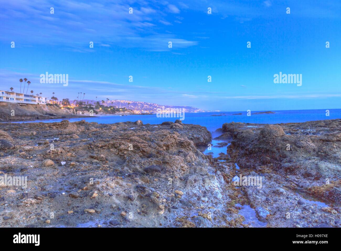 Tramonto sulle rocce a Shaws Cove nella Laguna Beach come flussi di acqua sopra la pietra in HDR Foto Stock