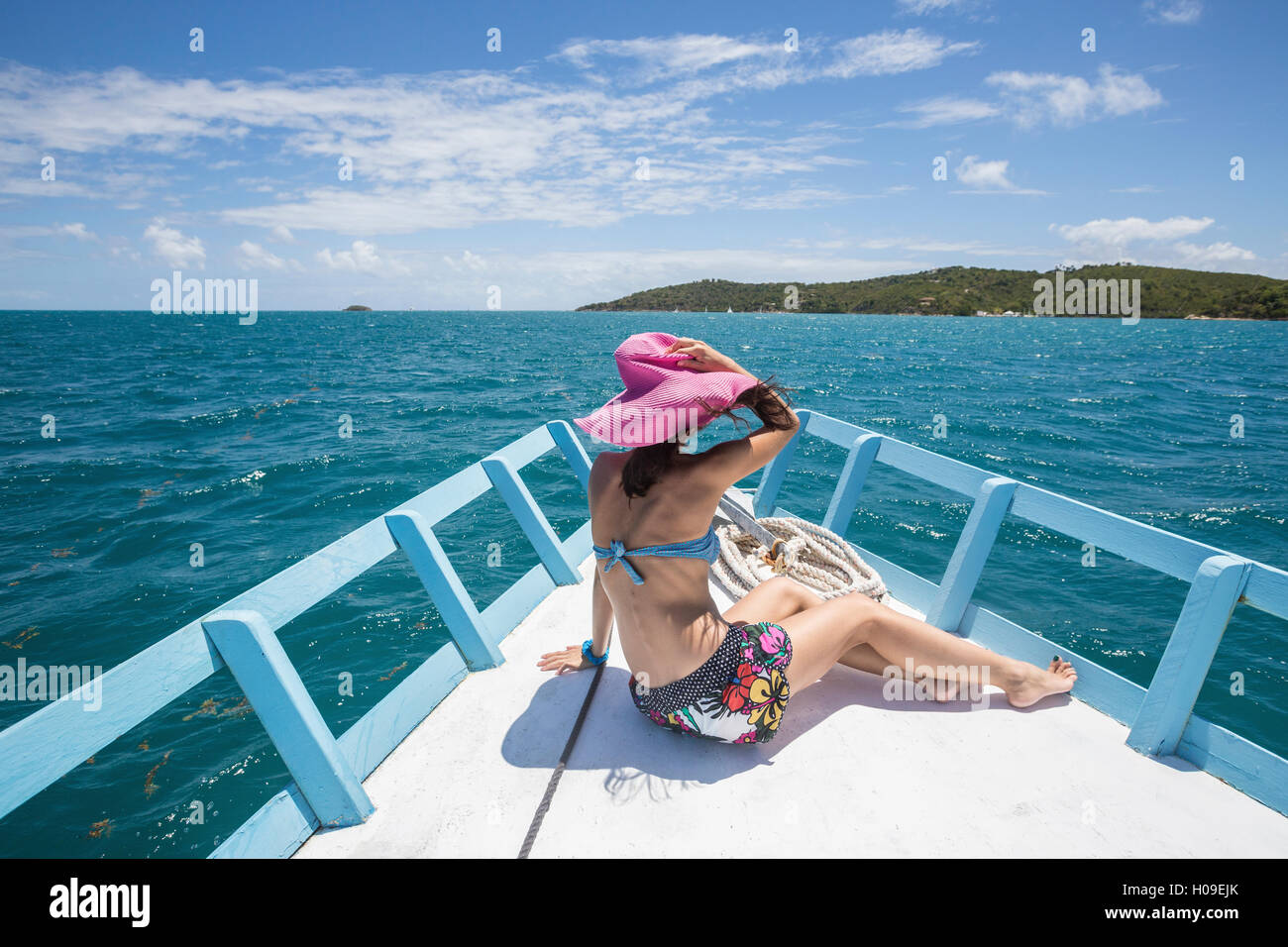 Un turista ammira i colori del mare dei Caraibi da una barca, Isola Verde, Antigua e Barbuda, Isole Sottovento, West Indies Foto Stock