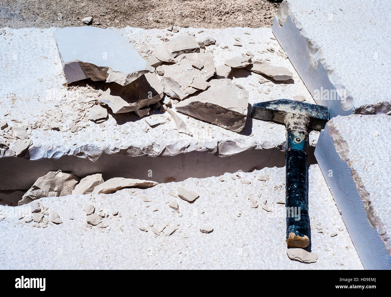 Costruzione di un martello, la pila di lastre calcaree scavate pavimentazione stradale. Featured vive in scaglie di calcare scheggiate e frantumato durante il pro Foto Stock