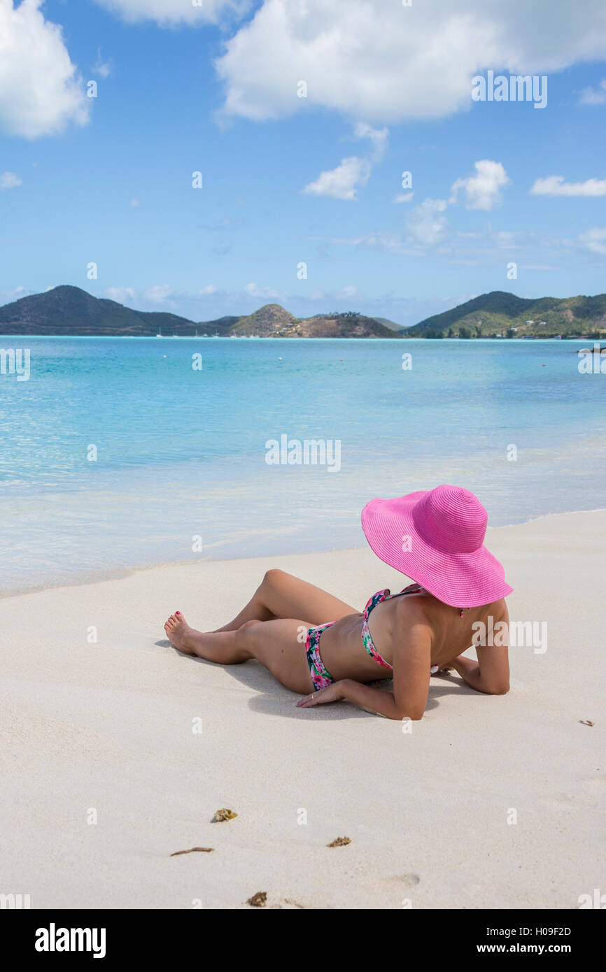 Signora sulla sabbia circondata da turchese del Mare dei Caraibi, Ffryes Beach, rocce a picco, Antigua e Barbuda, Isole Sottovento Foto Stock