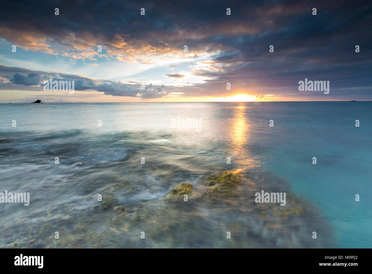 Le luci del tramonto si riflettono nel mare blu, Hawksbill Bay, Antigua Antigua e Barbuda, Isole Sottovento, West Indies Foto Stock