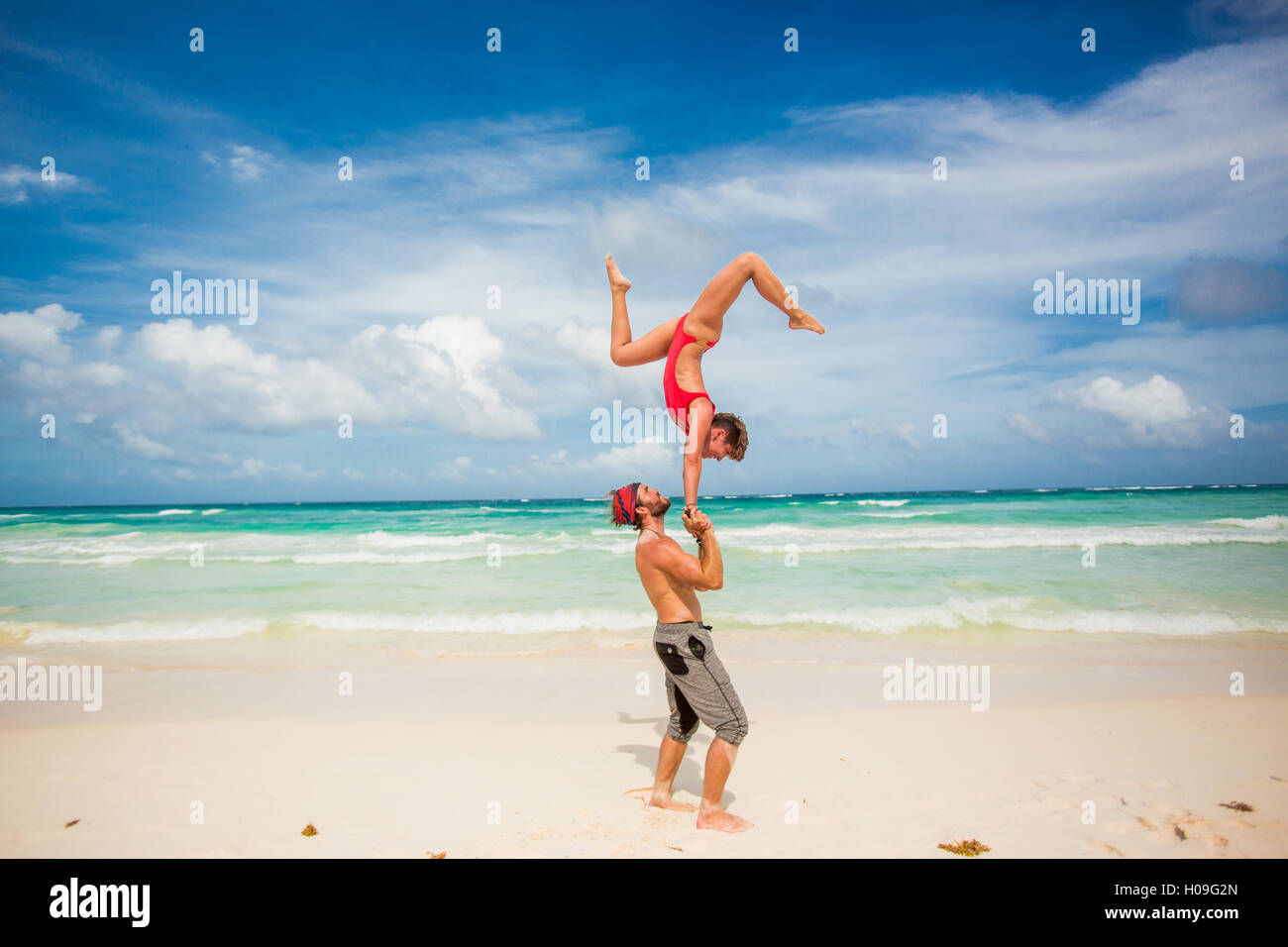 Coppia acrobatica assieme di bilanciamento sulla spiaggia di Tulum, Messico, America del Nord Foto Stock