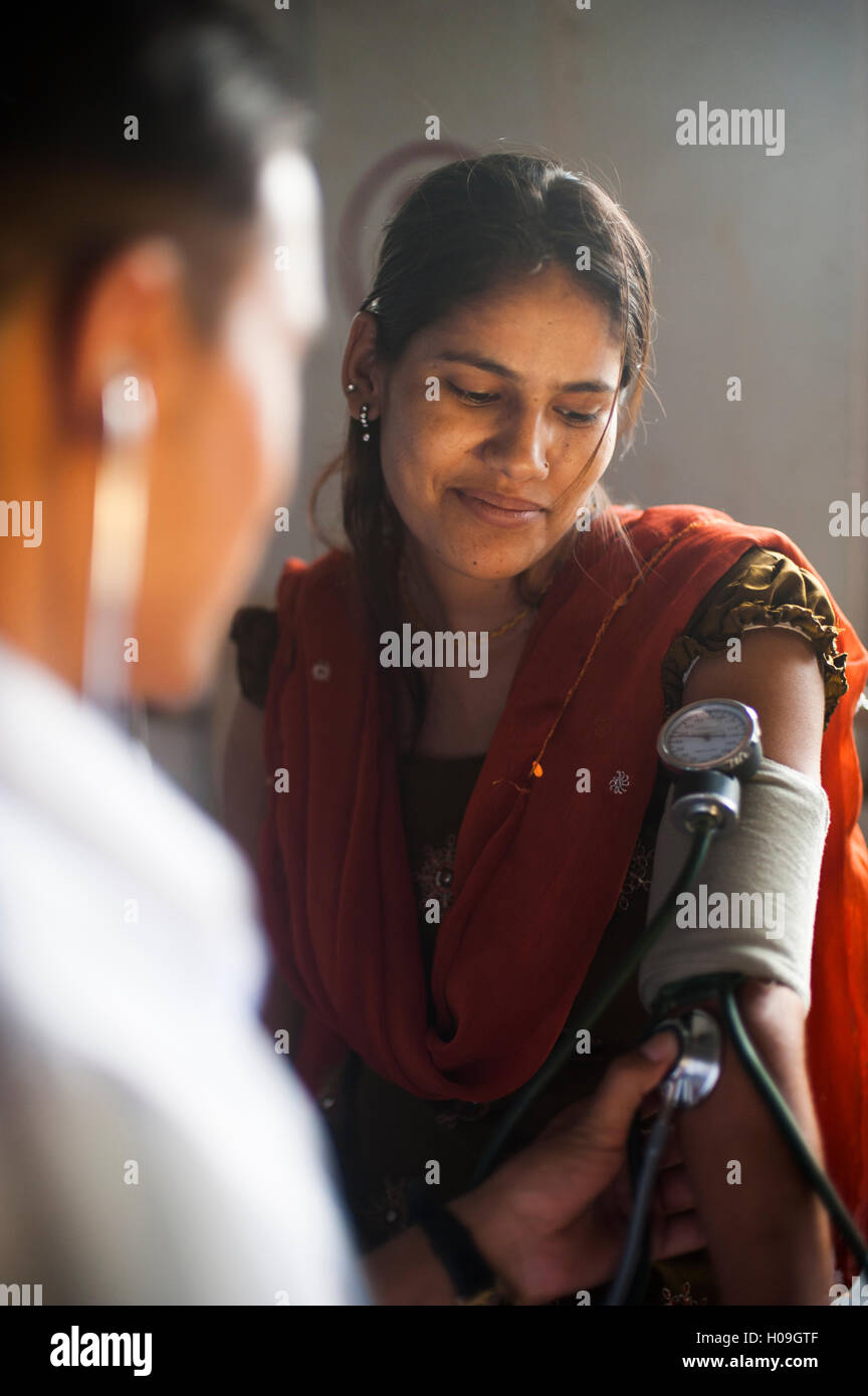 Un medico prende una donna e la pressione del sangue in un ospedale in Nepal, in Asia Foto Stock