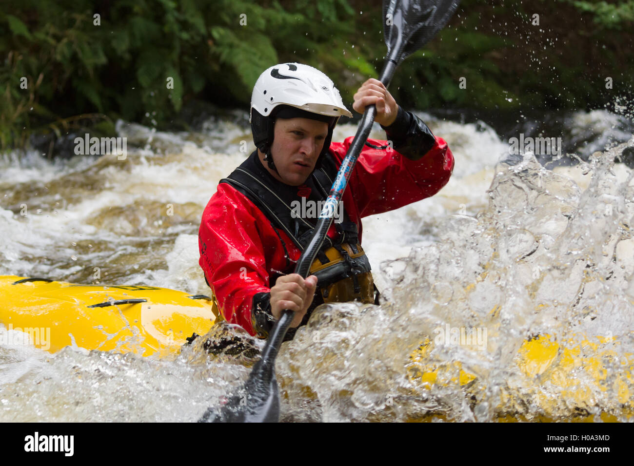 Acqua Bianca kayaker paddling attraverso rapids presso il National White Water centro sul fiume Tryweryn Frongoch Galles del Nord Foto Stock
