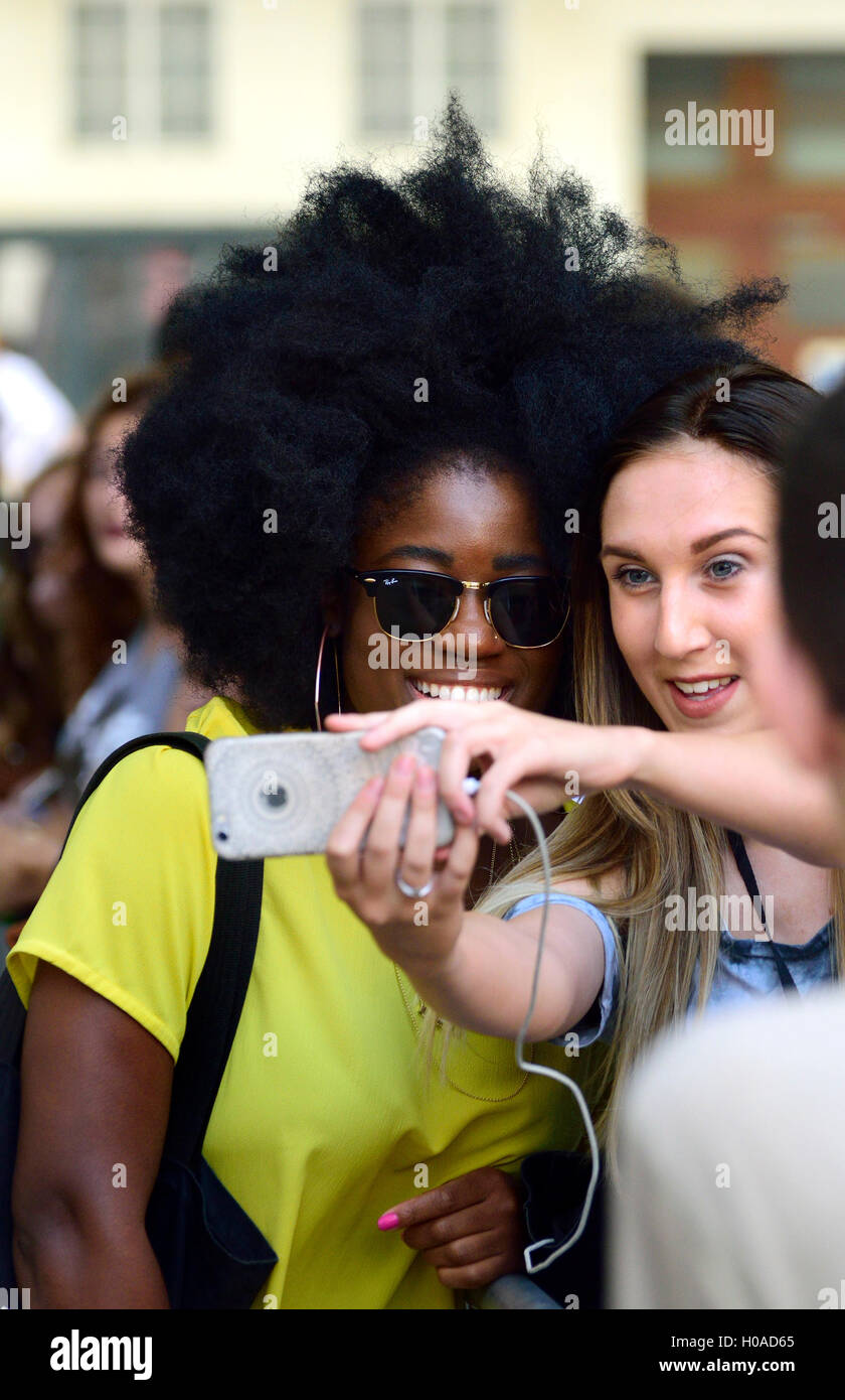 Clara Amfo, DJ su BBC Radio 1's metà mattina mostra, posa per selfies con ventole al di fuori della Radio 1 monolocali, Broadcasting House, Foto Stock