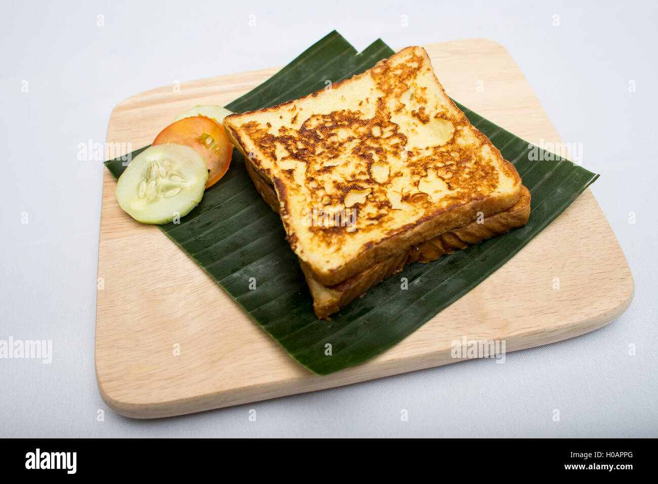 Vassoio indiano pasto con sandwich tostato e il cetriolo, pomodoro su foglia di banana Foto Stock