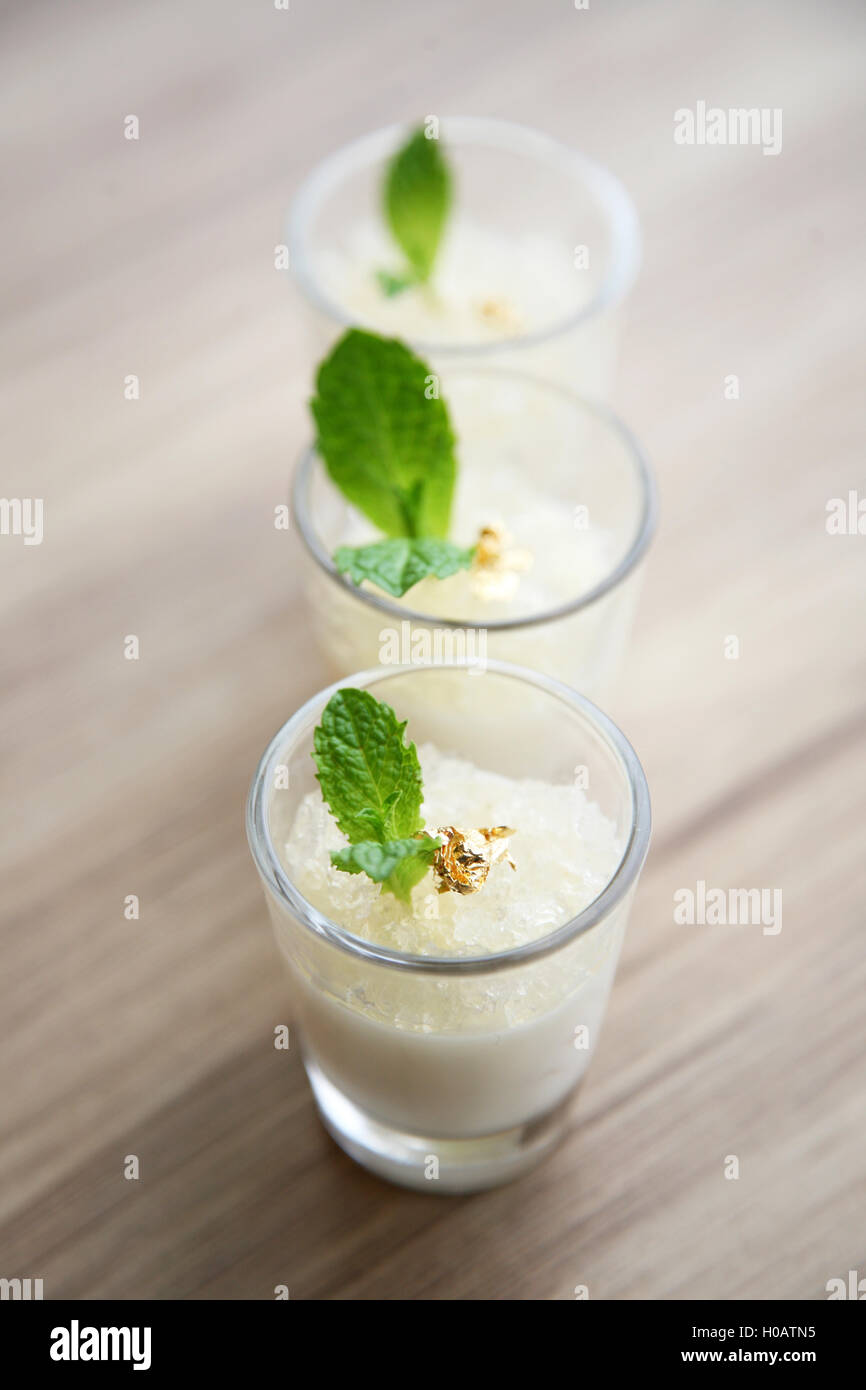 Budino di latte con pesce maws e foglia di menta in bicchieri Foto Stock