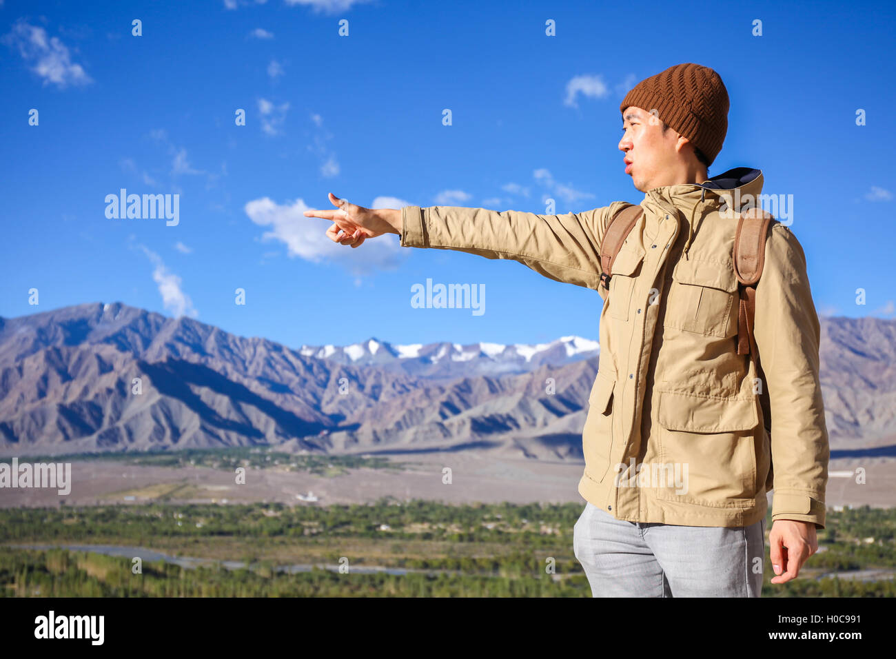 Giovani viaggiatori asiatici sottolineando il suo dito per prossime destinazioni in alta collina e cielo azzurro sfondo in Leh, Ladakh, India Foto Stock