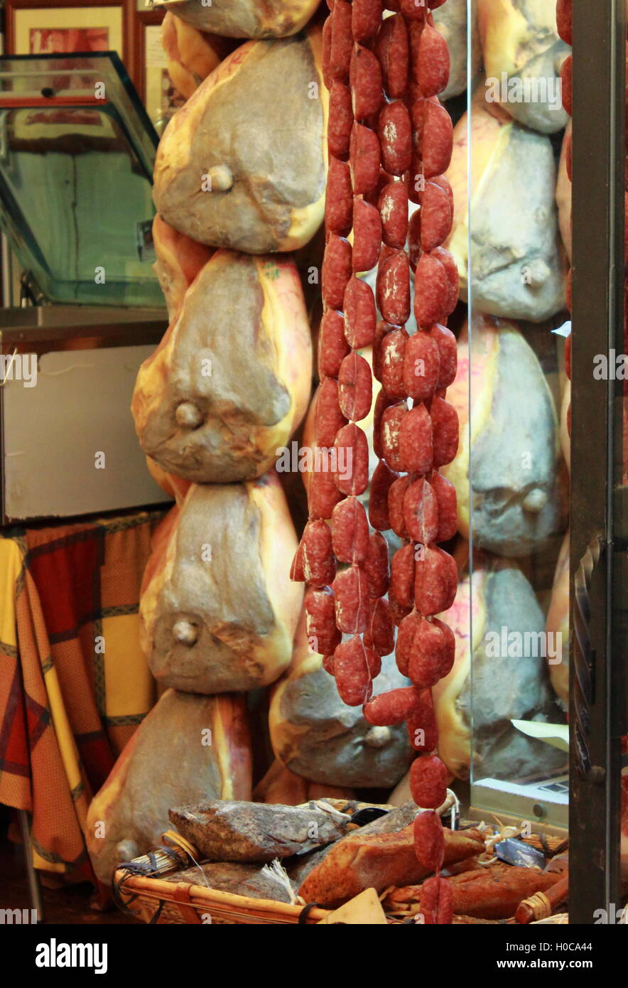 Differenti varietà di salumi appesi a un negozio di gastronomia Foto Stock